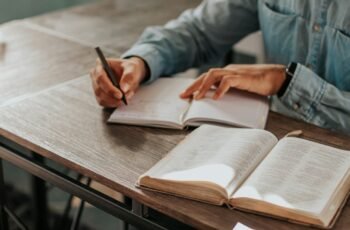 Person writing notes on paper while studying