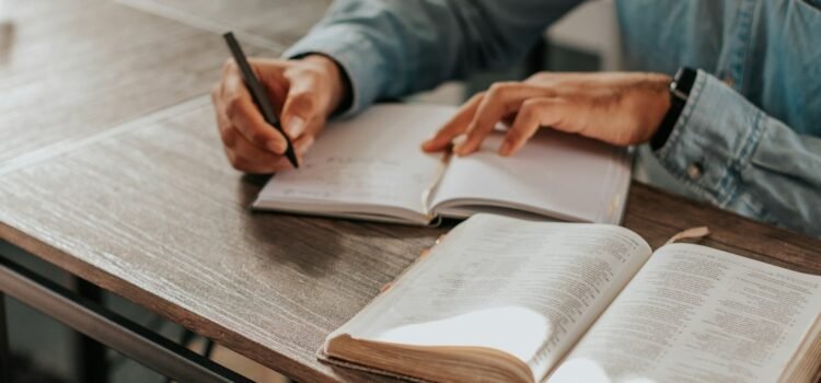 Person writing notes on paper while studying